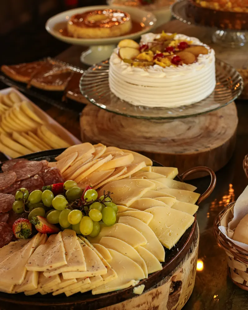 Tábua de queijos, frios e uvas no buffet.