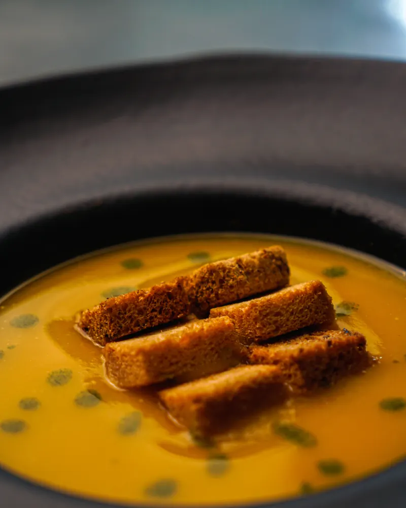 Sopa cremosa servida com torradas, prato da cozinha serrana do Mundo Neve.